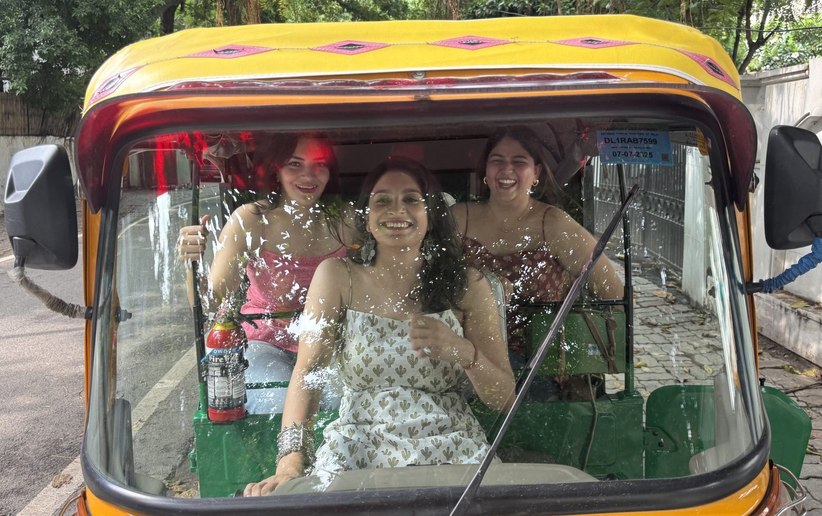 Three women in beautiful kurtis sitting in a rickshaw